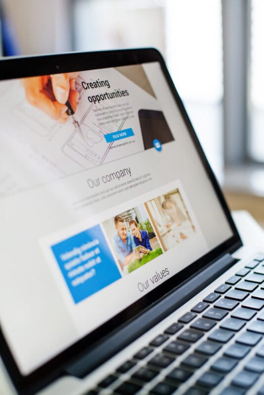 Asian Web Developers showcasing a modern business website on a laptop for a local Toronto small business owner.